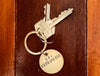 key chain with keys on dark timber